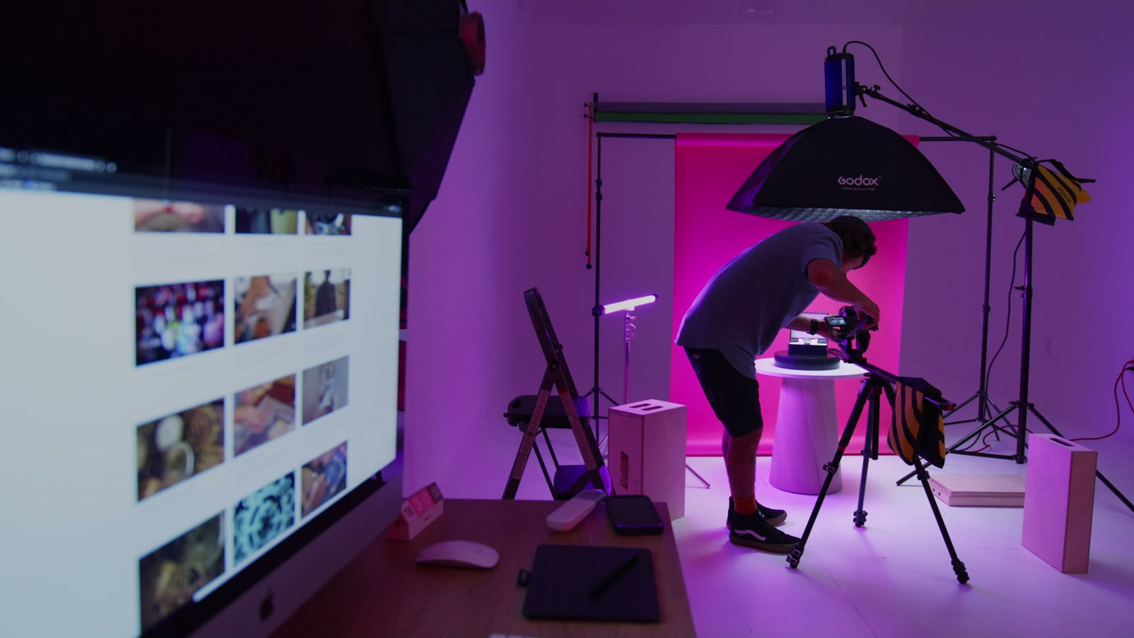 Studio de tournage plongé dans la pénombre, éclairages colorés et matériel de production