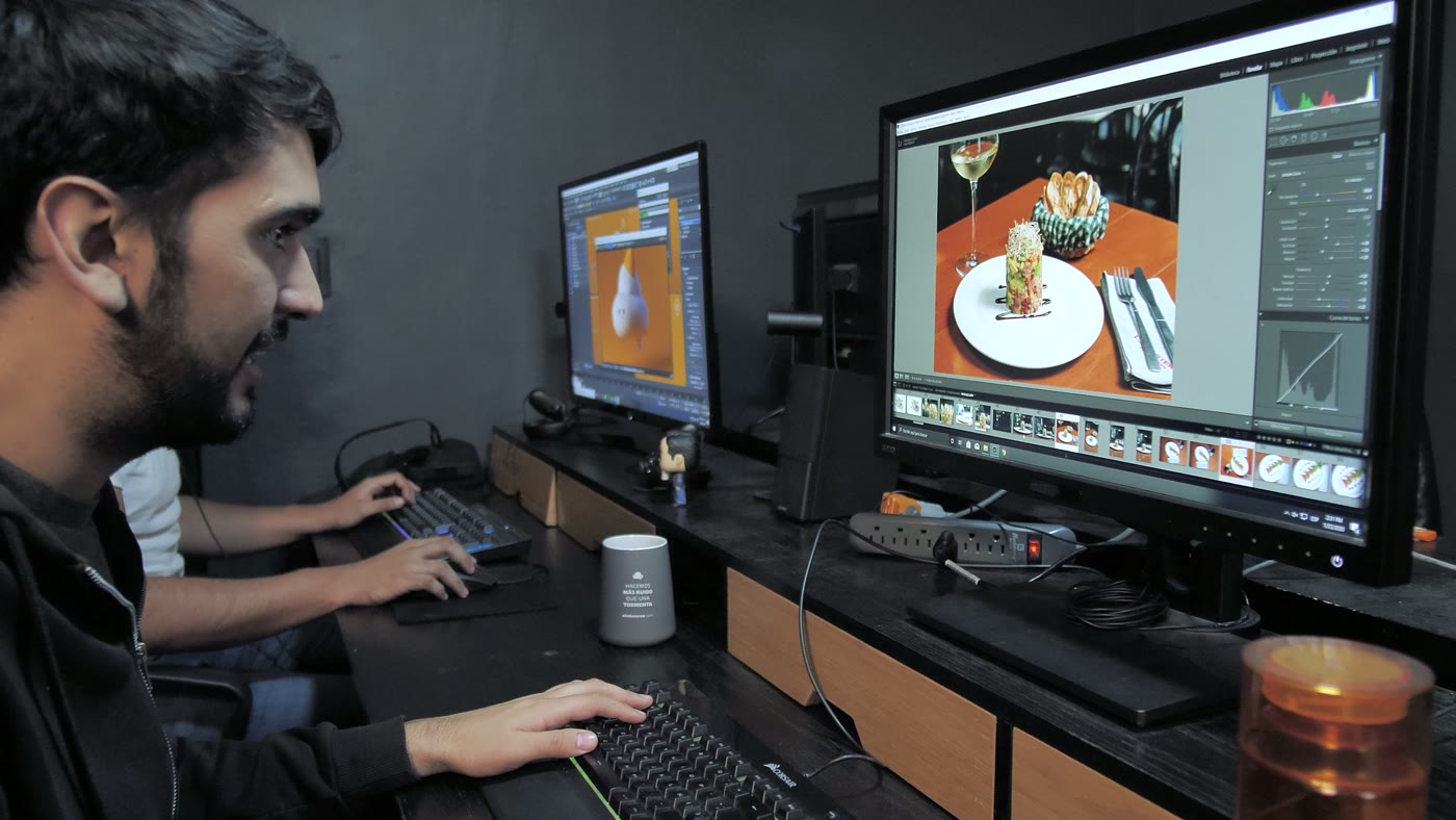 Directeur artistique travaillant sur plusieurs écrans dans un studio de création